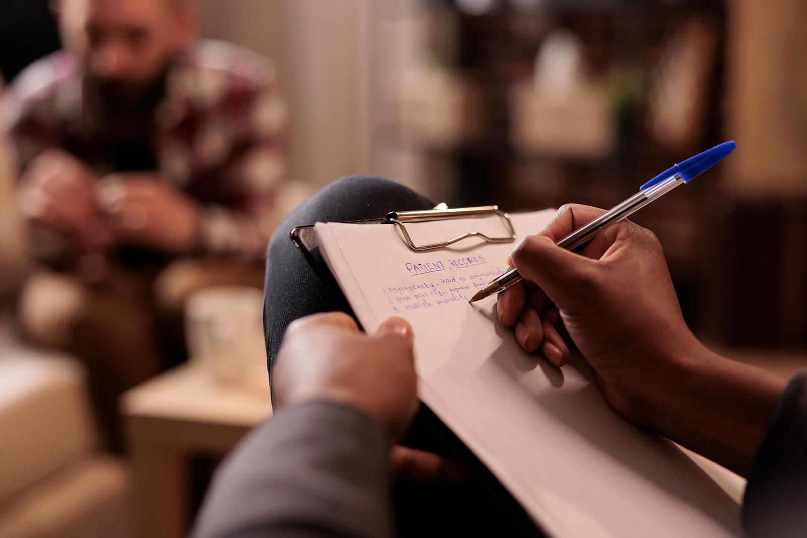 Psicólogo masculino tomando notas na sessão de terapia 